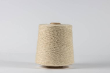 beyaz arkaplanda beyaz ipliğe sahip bobbin.
