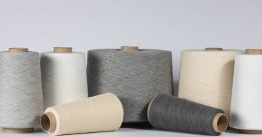 Beyaz izole arka planda pamuk iplikli eski püskü kıyafetler. Tekstil ve iplik endüstrisi kavramı