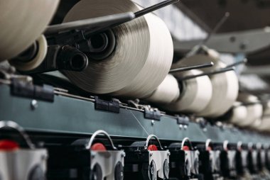 Fabrikadaki iplik makaralarını sarma süreci. Üretim hattı.