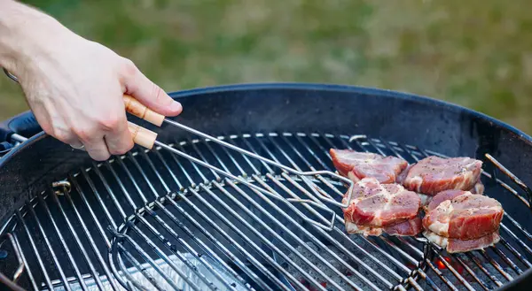 Färska Saftiga Köttbiffar Grillen Närbild Handen Med Koktång — Stockfoto