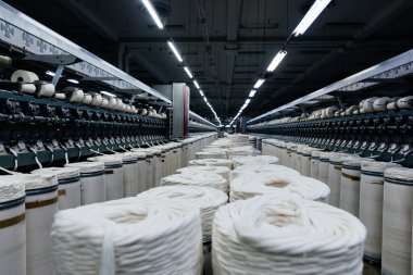 Makine aletlerinde dikiş tekstili üretimi için büyük sanayi pamuğu ruloları.