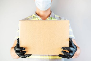 Koruyucu eldivenler ve maske takan servis elemanı. Teslimat servisi, online alışveriş ve lojistik konsept. Güvenli teslimat..