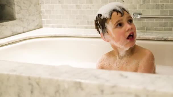 Мальчик играет в ванной. — стоковое видео