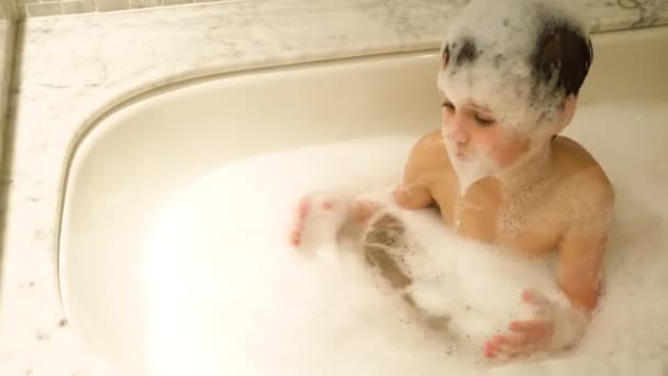 Kleiner Junge spielt in der Badewanne. — Stockvideo