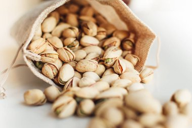 Arka planda fıstık yığını var. Pistachio sağlıklı bir vejetaryen protein yiyeceğidir. Vejetaryen gıda konsepti. Kapat..