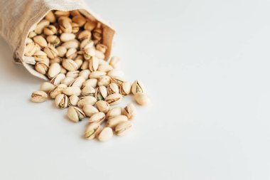 Arka planda fıstık yığını var. Pistachio sağlıklı bir vejetaryen protein yiyeceğidir. Vejetaryen gıda konsepti.