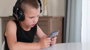 Akıllı telefonla oynayan genç bir çocuk..