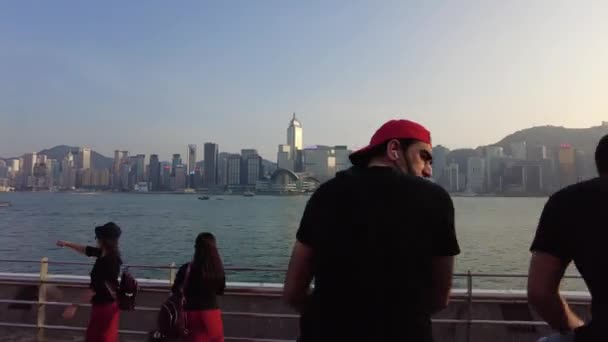 Hong Kong, China, 01 de novembro de 2020: Hiperlapso de pessoas caminhando na frente de água Tsim Sha Tsui no dia ensolarado — Vídeo de Stock