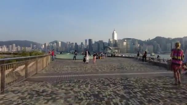 Χονγκ Κονγκ, Κίνα, 01 Νοεμβρίου 2020: Υπέρπτωση των ανθρώπων που περπατούν στο Tsim Sha Tsui μπροστά στο νερό την ηλιόλουστη μέρα — Αρχείο Βίντεο