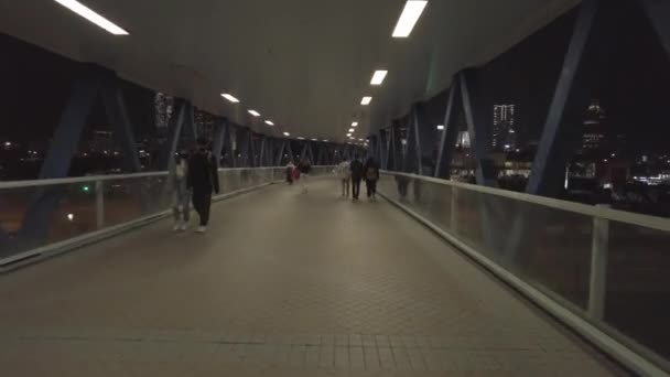 Гіперлапс дивиться на натовп зайнятих на пішохідному мосту в діловому районі. Центральний Гонконг вночі.; — стокове відео