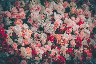 Pembe, beyaz ve kırmızı tonlarında sayısız yapay çiçekten oluşan canlı bir vintage fon. Kutlama için mükemmel..