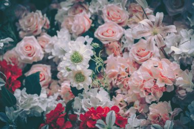 Yapay çiçeklerin güzel, klasik gösterisi, yumuşak pembe güller ve çeşitli çiçekler, neşeli bir kutlama için mükemmel..