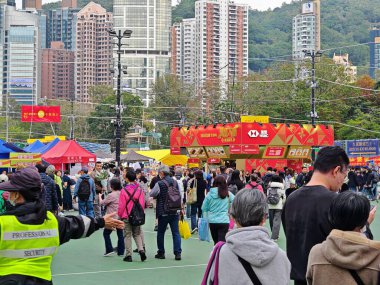 12 Şubat 2026 - Hong Kong, Çin: Victoria Park, 2026 'daki hareketli bir Yeni Yıl pazarının hipergerçekçi bir tasviri, çeşitli bir kalabalık ve şenlikli bir atmosfer sergiliyor..