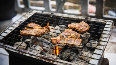 Piknik partisinde sıcak dumanlı mangalda pişirilmiş sosla marine edilmiş çiğ kuzu etinin yakın görüntüsü. Önplanda seçmeli odak.
