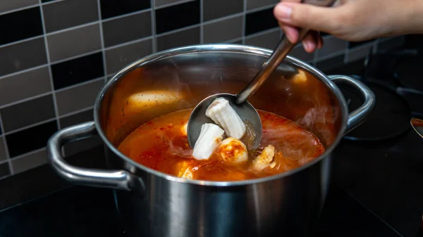 近距离观察手搅拌配料使奥登在热锅内使用金属勺 这是一个有名的日本街头菜式 — 图库照片