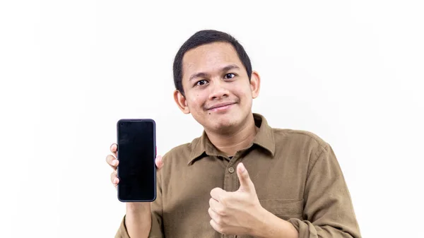 年轻的亚裔马来人满脸笑容 竖起大拇指 在孤立的白色背景上拿着装有空黑屏的智能手机 — 图库照片#