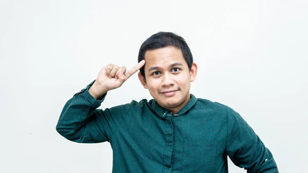 초록색 셔츠를 손가락 얼굴을 가리키며 미소짓고 잘생긴 아시아인 말레이인 배경에 — 스톡 사진