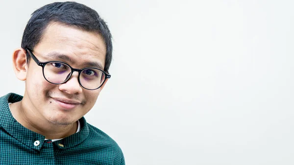 一个身穿绿色休闲装 戴着眼镜的亚裔马来人的画像 面带微笑地看着相机 相机上有独立的白色背景 — 图库照片