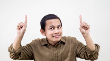 Gülümseyen ve gülen Asyalı Malezyalı genç bir adamın gülen yüz ifadesi. Kahverengi gömlekli, elleri boş, izole beyaz arka planı olan bir adam..