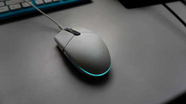 Close up view of white RGB led gaming mouse on the table. Selective focus.