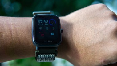 Sungai Buloh, Malezya - 12 Temmuz 2021: bileğinde Smartwatch Amazfit Bip U Pro. O, saat şeklinde takılabilir bir bilgisayardır. Verileri akıllı telefona senkronize edebiliyor. Nesneye seçici odaklanma.