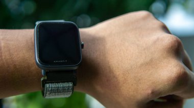 Sungai Buloh, Malezya - 12 Temmuz 2021: bileğinde Smartwatch Amazfit Bip U Pro. O, saat şeklinde takılabilir bir bilgisayardır. Verileri akıllı telefona senkronize edebiliyor. Nesneye seçici odaklanma.