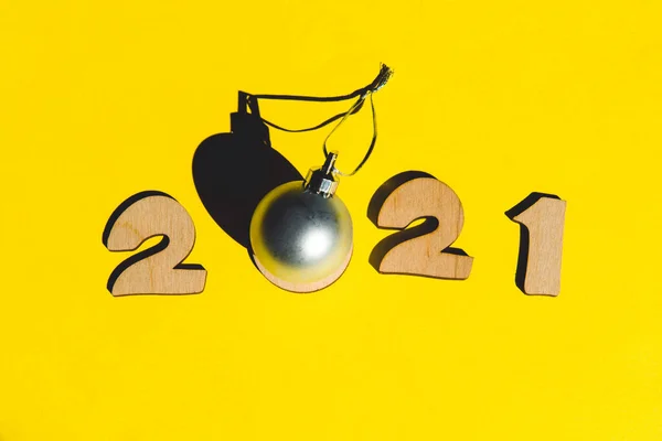 Nummer 2020 från trä bokstäver och jul boll på en gul bakgrund. — Stockfoto