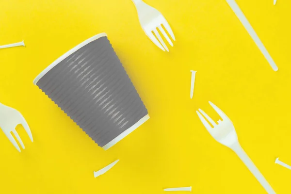 Pattern of broken plastic forks, and plastic cup on a yellow background. Ecology problem. — Stock Photo, Image