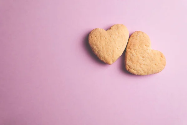 Dos galletas en forma de corazón una al lado de la otra sobre un fondo rosa. El concepto de San Valentín. — Foto de Stock