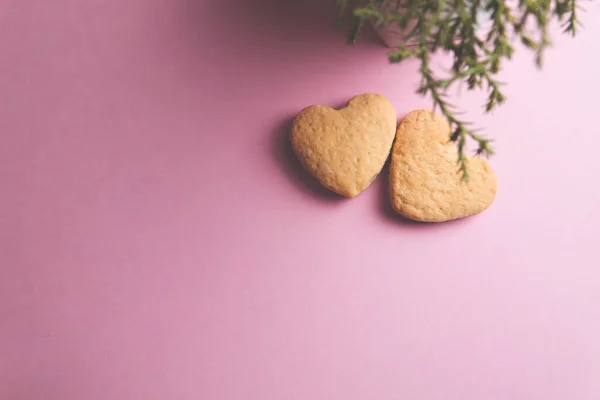 Dos galletas en forma de corazón una al lado de la otra sobre un fondo rosa. El concepto de San Valentín. — Foto de Stock