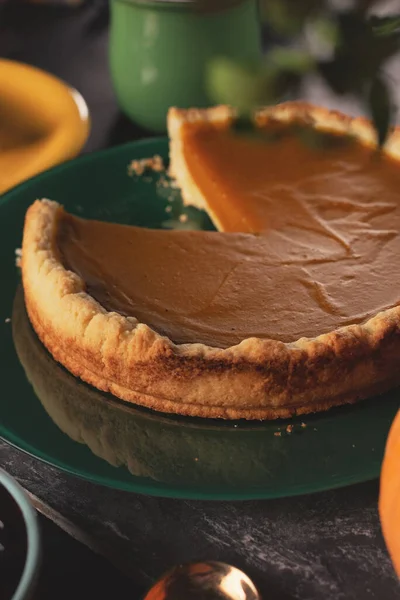 Torta de abóbora laranja para o Dia de Acção de Graças. uma fatia de torta de abóbora em uma placa amarela close-up em um fundo escuro. — Fotografia de Stock