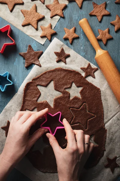 Der Prozess der Lebkuchenherstellung zu Weihnachten in Form von Sternen auf blauem Hintergrund — Stockfoto