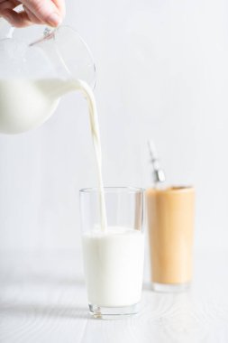 Modaya uygun bir Kore içkisi yapma süreci dalgonacoffee. Hafif arka planda sütü olan bir bardak ve sürahi..