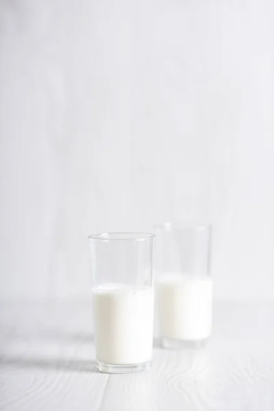 Milk in a glass on a light background. Breakfast. Milk cocktail preparation process. Copyspace — Photo