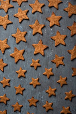 Noel için ev yapımı zencefilli ekmek, mavi arka planda yıldızlar şeklinde.