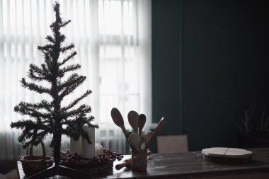 Pencerenin arka planında Noel ağacı, masada mutfak aletleri. Belirsiz efektli bulanık resim.