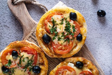 Ev yapımı pizza yapma süreci. Yukarıdan yakın plan pizza tahtanın üzerinde ve arka planda eski bir gazete var.