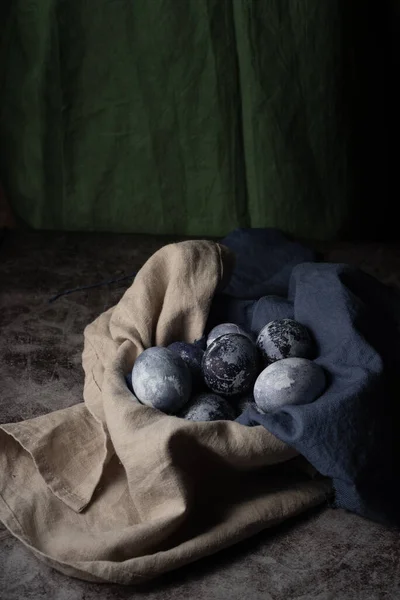 Páscoa ainda vida em um estilo rústico. ovos de mármore em uma tigela de barro em uma toalha no fundo de tecido de linho. Um método para tingir ovos com um corante natural feito de suco de mirtilo. — Fotografia de Stock