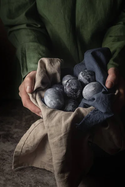 Γυναικεία χέρια κρατούν πήλινο κύπελλο με μαρμάρινα βαμμένα αυγά για το Πάσχα. Μια μέθοδος βαφής αυγών με φυσική βαφή χυμού βατόμουρου. στυλ χώρας. — Φωτογραφία Αρχείου