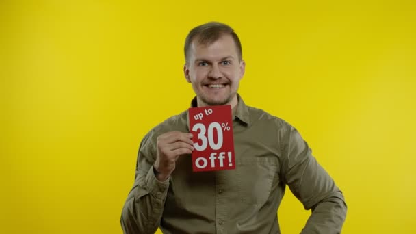 Šťastný muž ukazující slovo o prodeji a ukazující až 30% slevu. Radostné slevy — Stock video