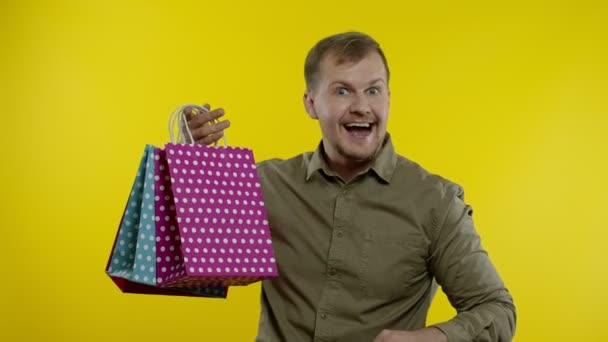 Man tonen tot 70 procent Off inscriptie en boodschappentassen, op zoek naar tevreden met lage prijzen — Stockvideo
