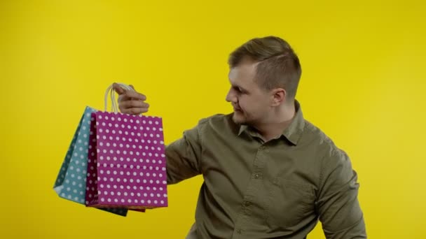 Man showing Up To 30 percent Off inscription and shopping bags, looking satisfied with low prices — Stock Video