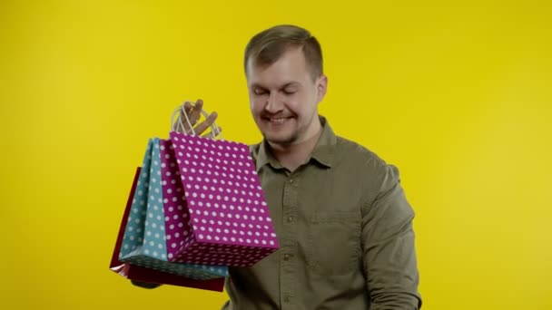 Man showing Up To 70 percent Off inscription and shopping bags, looking satisfied with low prices — Stock Video