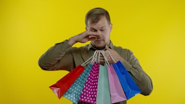Homem levantando sacos de compras, olhando satisfeito com a compra, desfrutando de descontos na Black Friday — Vídeo de Stock