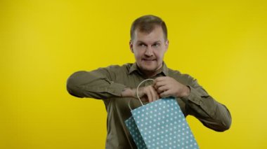 Alışveriş çantasındaki yazıyı gösteren, gülümseyen ve Kara Cuma 'da indirim yapan adam.