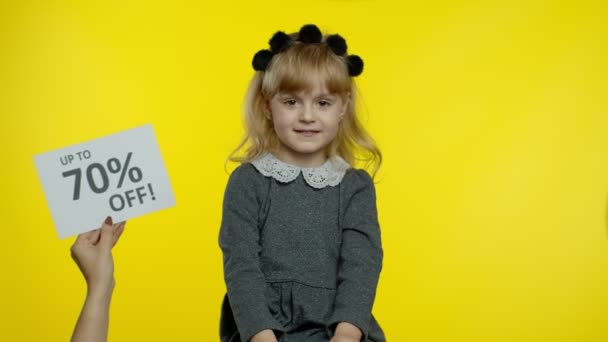 Inskriptionen Upp till 70 Procent Off visas bredvid leende barn flicka. Förskolebarn firar — Stockvideo