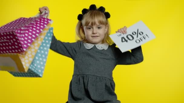 Niña mostrando hasta 40 por ciento Fuera de signo de inscripción y bolsas de la compra. Adolescente pupila sonriendo — Vídeos de Stock