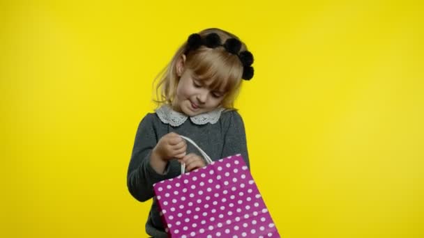 Kind meisje met boodschappentassen met zwarte vrijdag inscriptie, tevreden met lage prijzen kortingen — Stockvideo