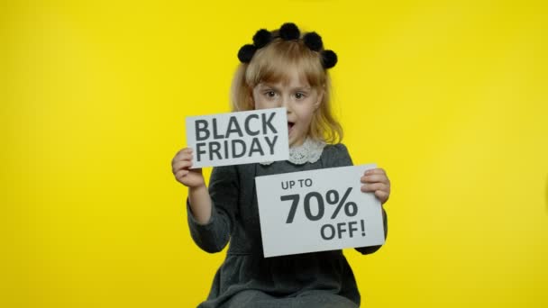 Kara Cuma 'yı gösteren kız çocuğu ve yüzde 70 indirimli reklam pankartları. Düşük fiyatlar, alışveriş. — Stok video
