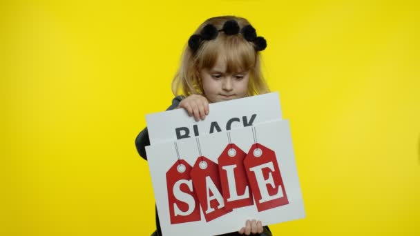 Χαρούμενη ξανθιά κορίτσι παιδί δείχνει Black Friday και Sale λέξη διαφημιστικές επιγραφές πανό — Αρχείο Βίντεο